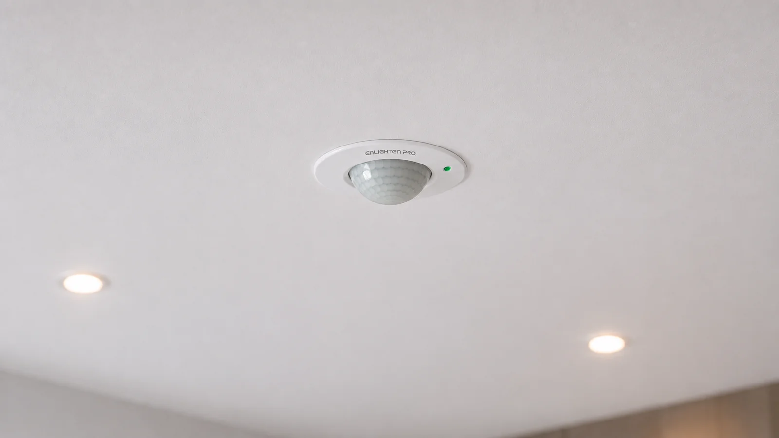 PIR Concealed Sensor EN-PIR-CM recessed into a ceiling, only the trim ring and dome sitting flush with the plaster